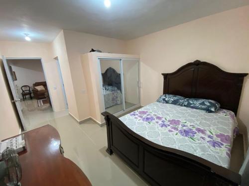 Un dormitorio con una cama, una cómoda y una mesa. en Casa amarilla, en La Romana