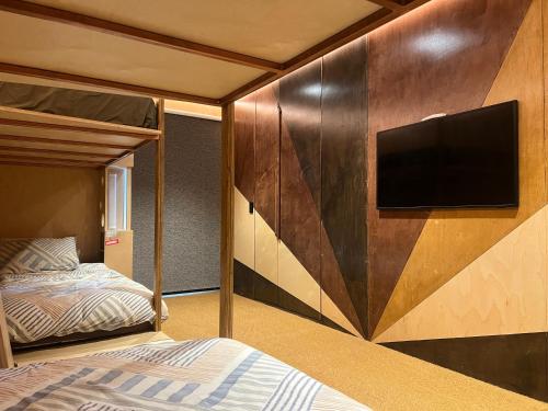 ワナカにあるPoolside Peaks - designer house, spa, fire, poolのベッドと壁掛けテレビのある寝室