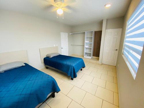 Ramos ArizpeCasa Recién-Remodelada Ideal, Ejecutivos, Trabajos的一间带两张床和吊扇的卧室