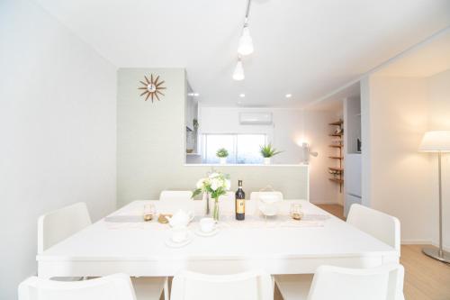 a white dining room with a white table and white chairs at ナガシマリバーサイドリゾート - Vacation STAY 94113v in Kuwana