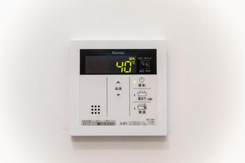 a white machine with a digital clock on a wall at ナガシマリバーサイドリゾート - Vacation STAY 94113v in Kuwana