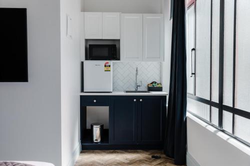 ネイピアにあるCriterion Hotel Napierのキッチン(青いキャビネット、電子レンジ付)