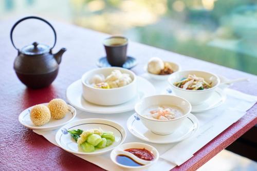 un vassoio di cibo su un tavolo con ciotole di cibo di The Peninsula Tokyo a Tokyo