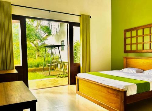 Un dormitorio con una cama y una puerta corrediza de vidrio. en Pinnacle Life, en Matale