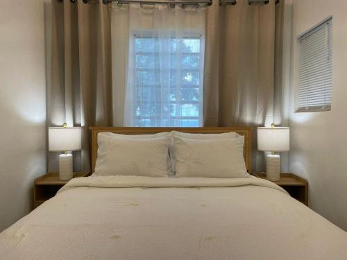 Un dormitorio con una cama grande con dos lámparas. en Abigail's Sunlit Nook, en Isla Tórtola