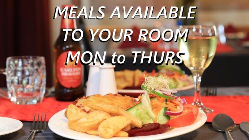 a plate of food on a table with a glass of wine at Barham Riverland Motel in Barham