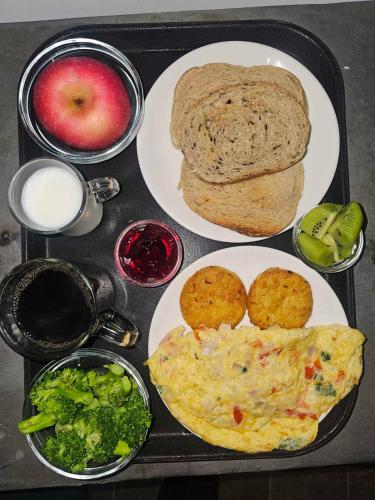 Una bandeja de comida con huevos, brócoli y pan. en Sagarmatha Apartment Hotel, en Pātan