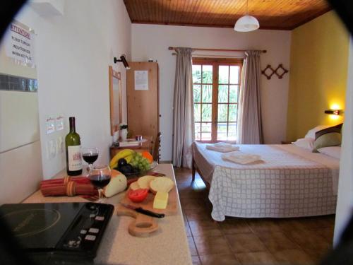a room with a bed and a kitchen with a sink at Spiti Melianou in Agios Georgios Pagon