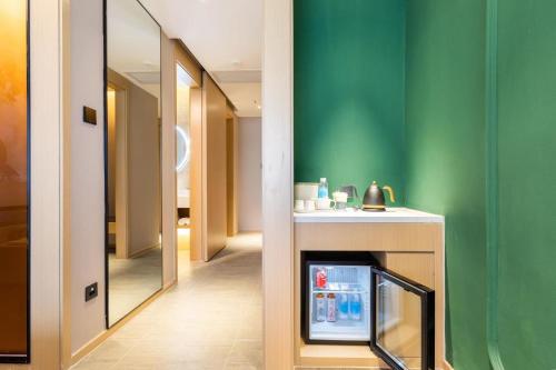 a living room with a television and a green wall at Atour Hotel Wuhan Chuhehanjie Xiu Theater in Wuhan