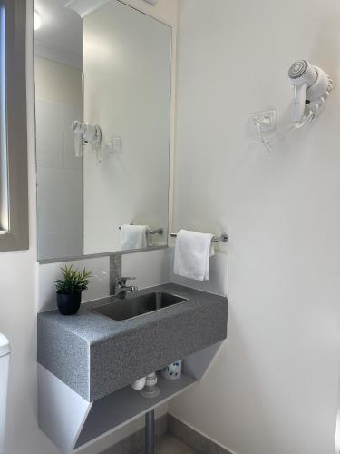 a bathroom with a sink and a mirror at Reef Gardens Motel in Proserpine