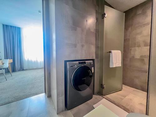 a bathroom with a washing machine in a room at LN Residence Changdi New Aiqun Building in Guangzhou