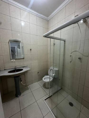 Un baño con ducha, inodoro y lavabo. en Casa 140, en Guarujá