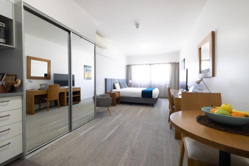 a hotel room with a bedroom and a dining room at MainStay Suites Mackay in Mackay