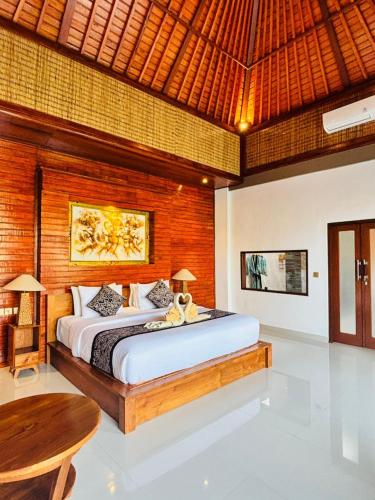 a bedroom with a large bed and a wooden ceiling at Uma Galih Ubud Villa in Ubud