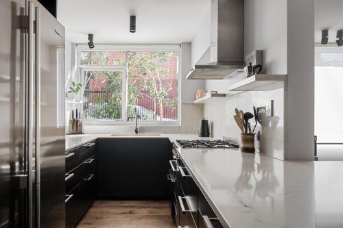 a white kitchen with a sink and a window at Garden oasis in the heart of Fitzroy in Melbourne