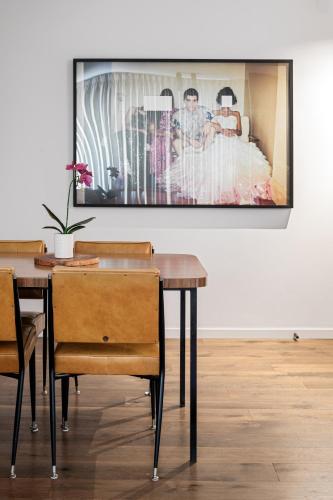 a dining room table with a picture on the wall at Garden oasis in the heart of Fitzroy in Melbourne