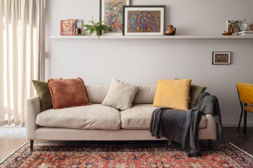 a living room with a couch with pillows on it at Garden oasis in the heart of Fitzroy in Melbourne