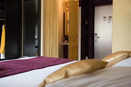 a close up of a bed with a gold object on it at Charme et Caractère Le Turenne in Beaulieu-sur-Dordogne