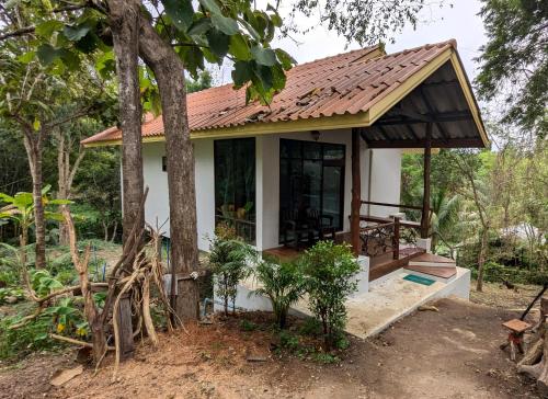 a small white house with a brown roof at Open Mind Center Villas in Ban Tha Pai