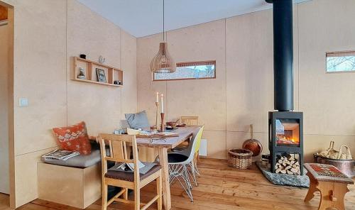 a dining room with a table and a wood stove at Self-Built Cabin With Views Over Leirvik in Leirvik