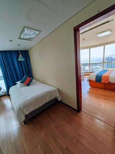 a bedroom with a bed and a large window at East King Business Hotel (West Lake store, Hangzhou) in Hangzhou