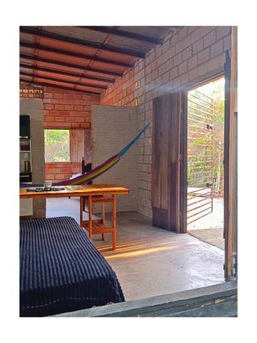 a room with a table and a hammock in it at Casa Segredo da Mata in Alter do Chao