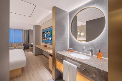 a bathroom with a sink and a mirror at Orange Hotel Beijing Xi'erqi in Beijing