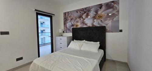 ein Schlafzimmer mit einem Bett mit einem Blumenwandbild an der Wand in der Unterkunft Skyline Stay in Male City
