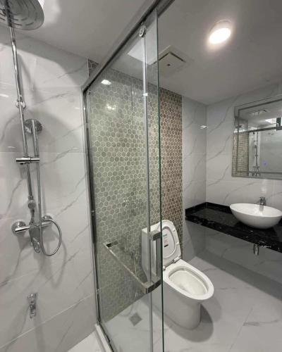 a bathroom with a shower and a toilet and a sink at Skyline Stay in Male City