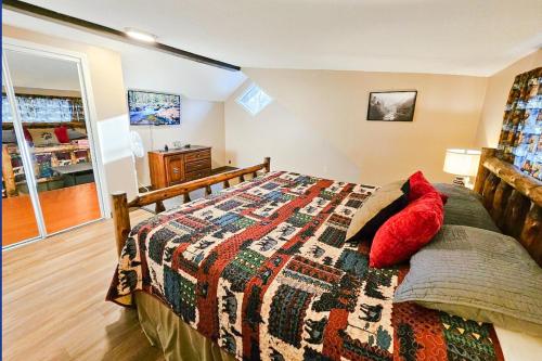 a bedroom with a bed with a red pillow on it at The Bearfoot Cabin! Ideally located, decorated for Christmas, Fireplace, Game Room! in Sevierville