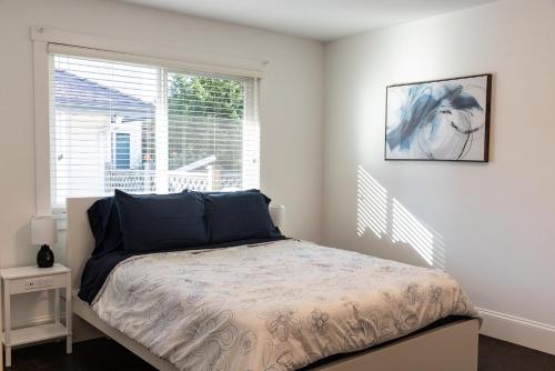 ein Schlafzimmer mit einem Bett vor einem Fenster in der Unterkunft The Langley Courtyard Home 2BR, 2BA for 6 Guests in Langley
