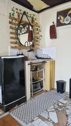 een keuken met een zwarte koelkast in een kamer bij GNOME KIT HOUSE São Tomé das Letras- Mg in São Thomé das Letras