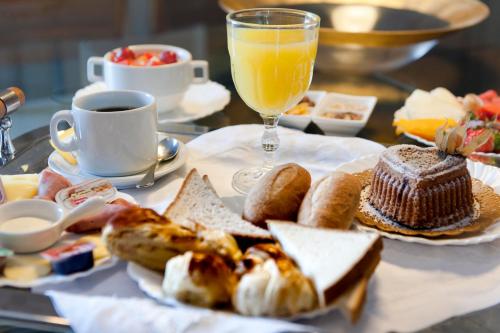 a plate of food with bread and a glass of orange juice at Comfort Hotel Fortaleza in Fortaleza