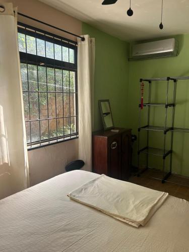 a bedroom with a bed and a window at Surf House Aparment in Coco