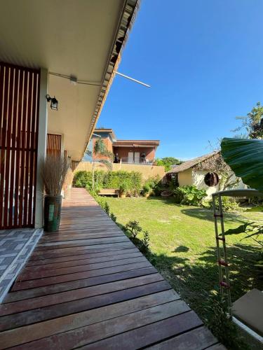 a wooden walkway leading to a house with a yard at La Depa PP House in Phi Phi Islands
