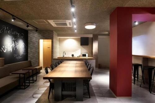 a dining room with a long table and chairs at Shinsaibashi House in Osaka