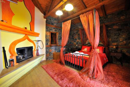 a bedroom with a bed in a room with a fireplace at Guesthouse Nifada tou Vorra in Palaios Agios Athanasios