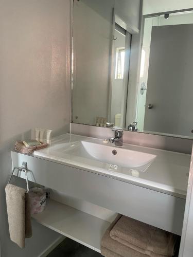 a bathroom with a white sink and a mirror at Aaron Court Motel Whangarei in Whangarei