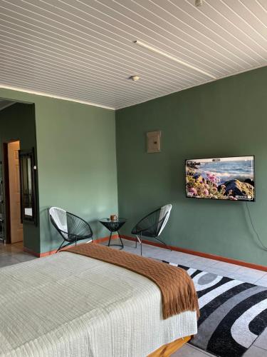 a bedroom with a bed and a tv on the wall at Big Sloth Apartment in Fortuna