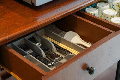 a drawer in a cabinet with dishes and utensils at Rumah Canda in Bandung