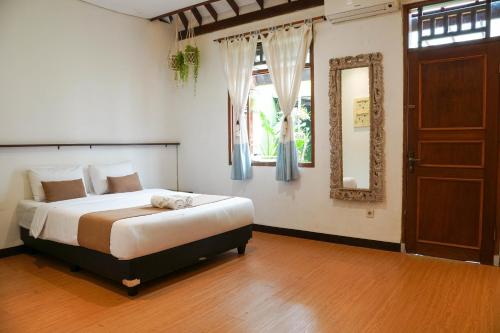 a bedroom with a bed with a mirror and a window at Rumah Canda in Bandung