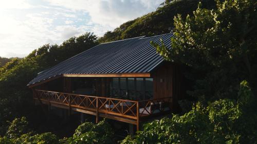a house with a solar roof on a hill at Turtle Beach Hotel Calibishie in Woodford Hill