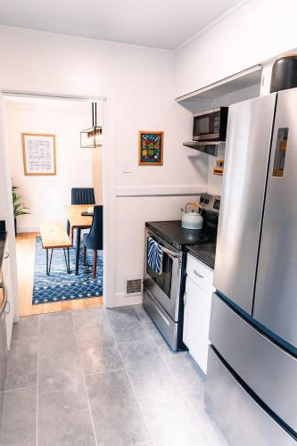 a kitchen with a refrigerator and a table at Profs Riverside Haven Art & Style Sleeps 10 in South Bend