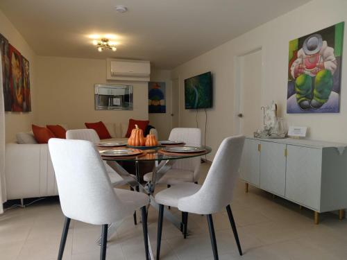 a dining room with a table and white chairs at Apartamento San Andrés 