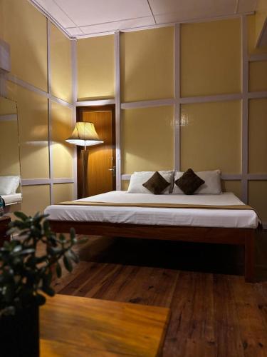 Un dormitorio con una cama grande con una pared. en Tuckedinn home, en Shillong