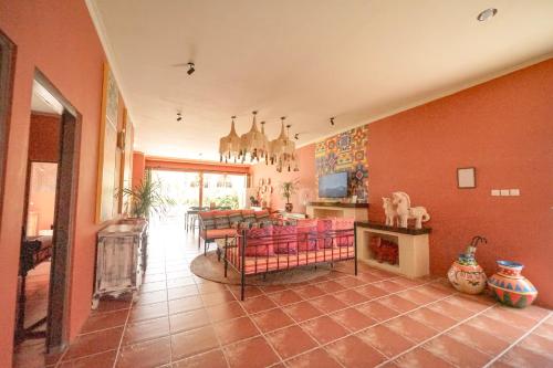 a living room with red walls and a dining room at Amador by Suasana Villa in Jarakan