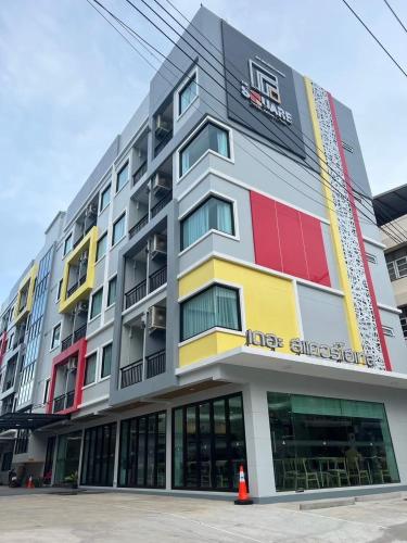 a large apartment building with colorful windows at The Square Hotel เดอะสแควร์โฮเทลนครพนม in Nakhon Phanom