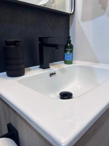 a bathroom sink with a bottle of soap on it at Cozy Home away from home! in Miami