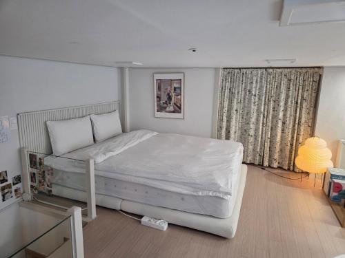 een slaapkamer met een groot wit bed in een kamer bij Hongdae Luxury Stay in Seoul
