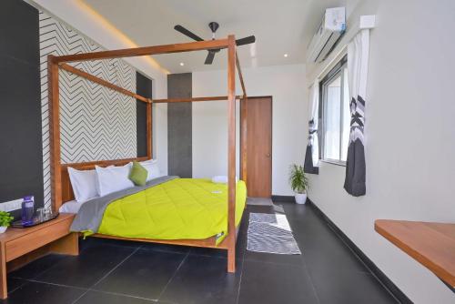 Villa With Turf & Indoor Games في Malavli: غرفة نوم بسرير مع لحاف اصفر